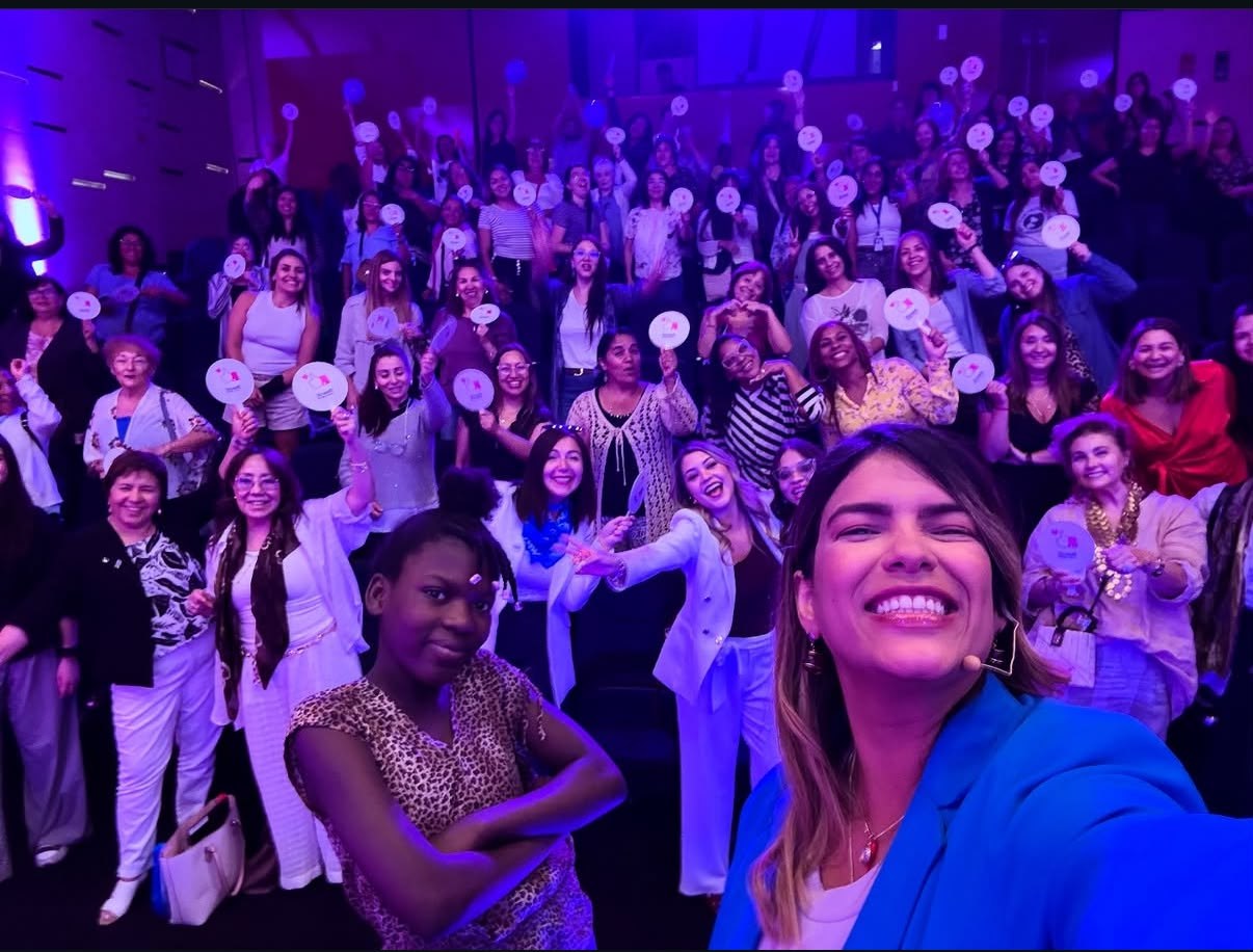 Katherine Rivas con un auditorio lleno de participantes detrás